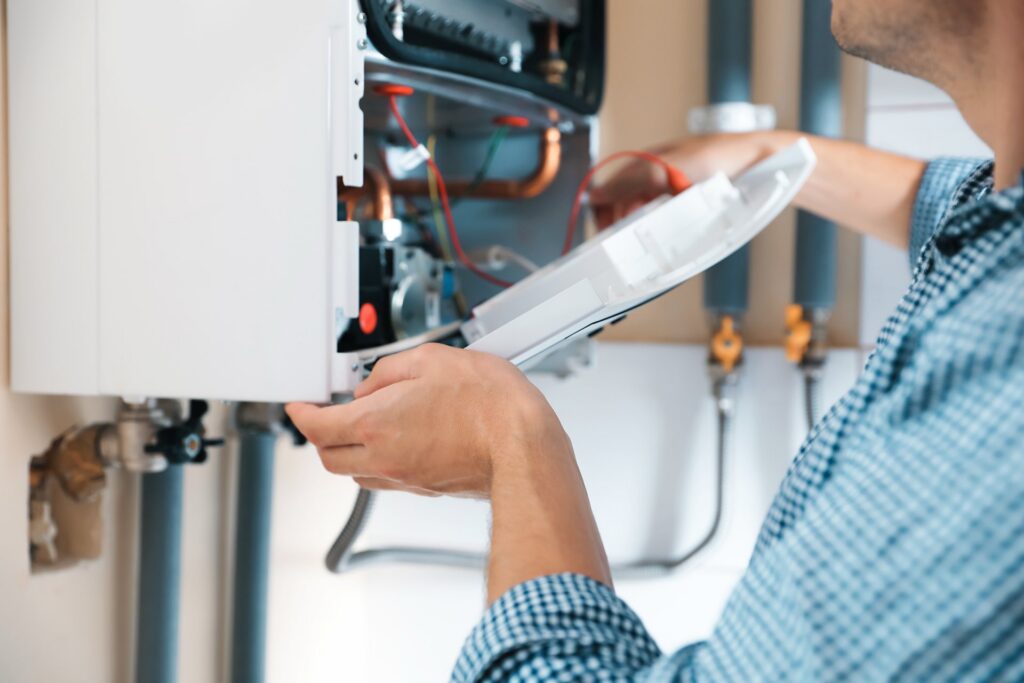 Person opening top of gas boiler, closeup
