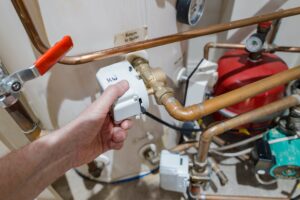 Persons hand holding a chord on a boiler