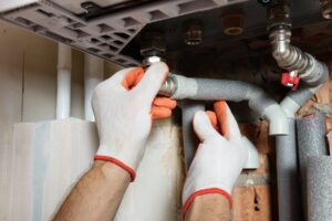 Hands with gloves on touching pipes